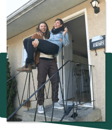 photo of two friends standing at the front door of their new investment property
